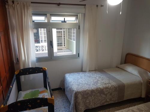a small bedroom with a bed and a window at Sol y Playa in Puerto Naos