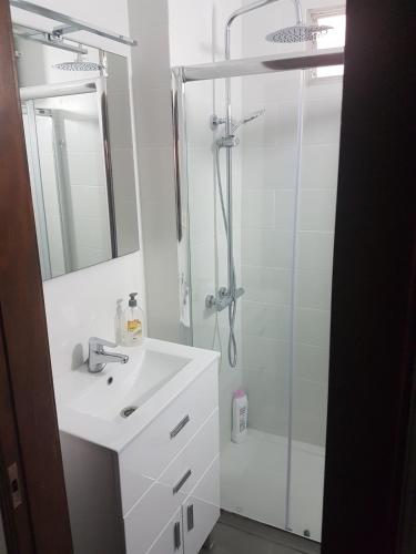 a white bathroom with a shower and a sink at Sol y Playa in Puerto Naos