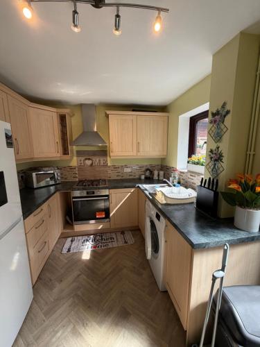 a kitchen with wooden cabinets and a white refrigerator at Real Home In Northampton in Overstone