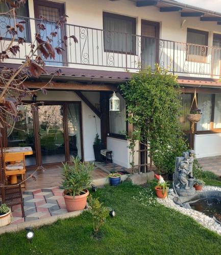 a house with a patio and a yard with plants at Casa Narciselor in Râşnov