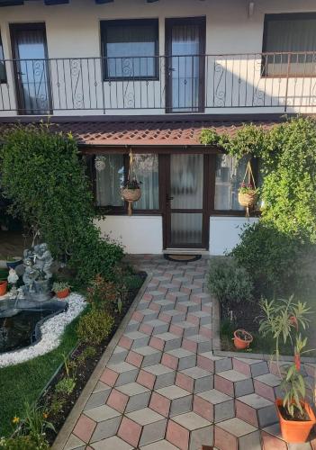 a courtyard of a house with plants and a balcony at Casa Narciselor in Râşnov