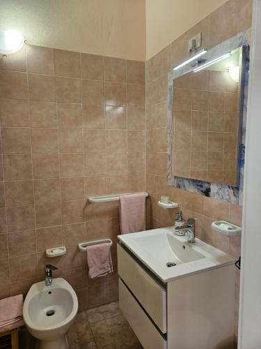a bathroom with a sink and a toilet at La Rosa dei Venti B&B in Chia