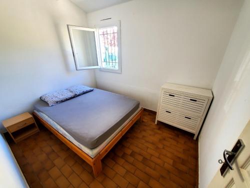 a small bedroom with a bed and a window at maison individuelle in Le Grau-du-Roi