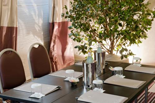 a black table with chairs and a tree in the background at Brunelleschi Hotel in Florence