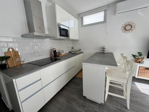 a kitchen with white cabinets and a table and chairs at Apartamento Maravía La Restinga in La Restinga