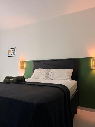 a bedroom with a large bed with a green wall at Loft Marinês in Campina Grande