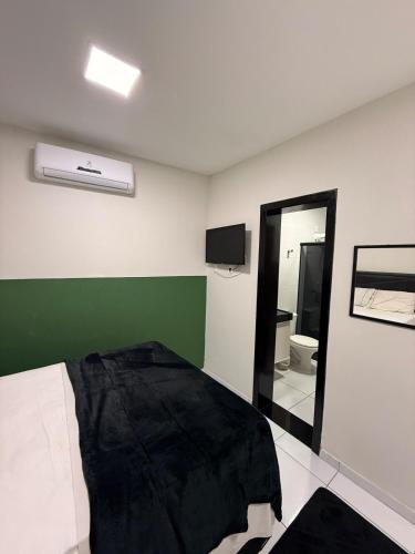 a bedroom with a bed and a green wall at Loft Marinês in Campina Grande