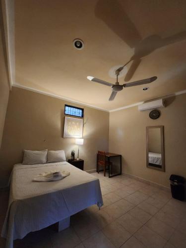 a bedroom with a bed and a ceiling fan at Posada Azeneth in Oxkutzcab