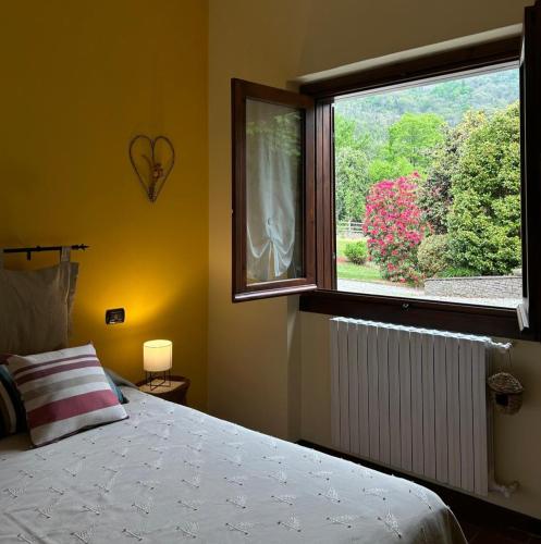 a bedroom with a bed and a large window at B&B Il Picchio in Mergozzo