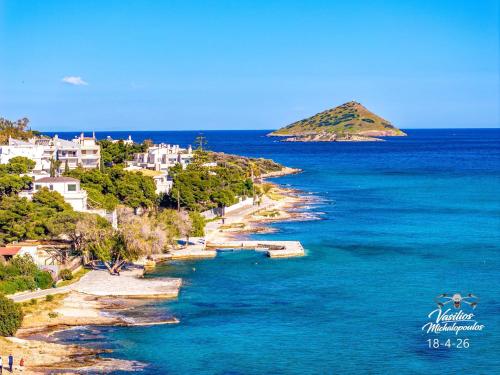 an island in the ocean with blue water and houses at 4 Seasons Island Suites Athens Airport in Markopoulo