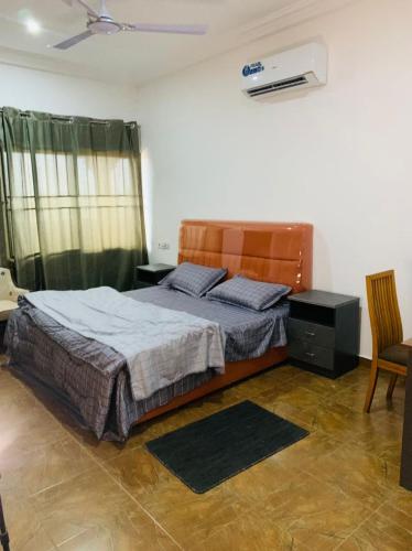a bedroom with a bed and a chair at Water House Lodge in Apenkwa