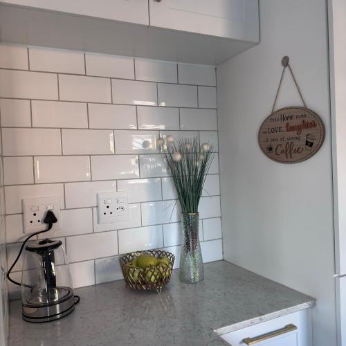 a kitchen counter with a vase with flowers on it at Terrys place in Malmesbury