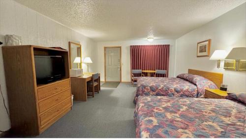 a hotel room with two beds and a flat screen tv at North Winds Lodge LLC in Bowman