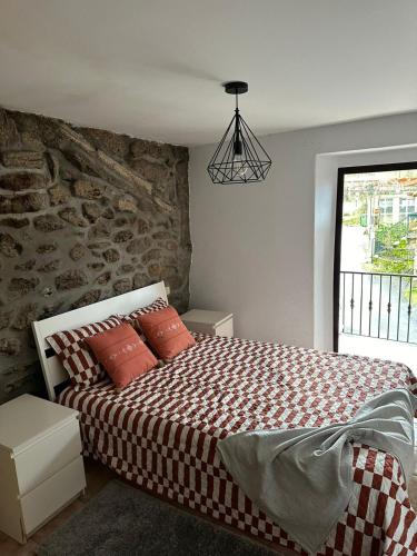 a bedroom with a bed with a brick wall at Lobios House in Bubaces