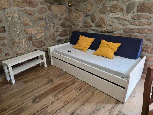a bed with yellow pillows on it in a room at Lobios House in Bubaces