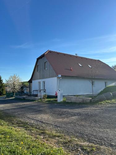 a large white barn with a black roof at Brezový dvor in Svätý Anton