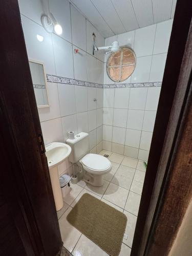 a bathroom with a toilet and a sink at Pousada Vento Leste in Cabo Frio