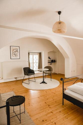 a living room with two chairs and a bed at KOKORO am Kirchplatz in Sankt Veit am Vogau