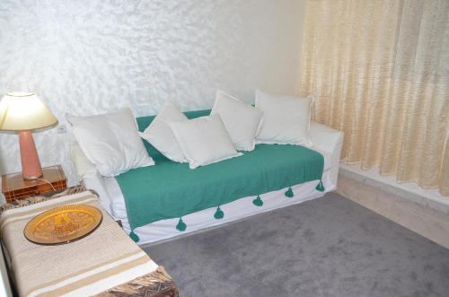 a living room with a green couch with white pillows at Residence 33 vèrte in Guelmim