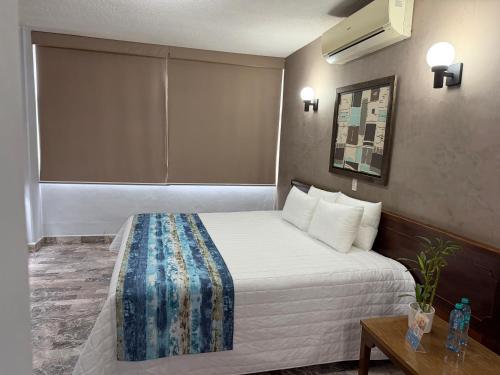 a hotel room with a bed and a table at Hotel Plaza in Tuxpan de Rodríguez Cano
