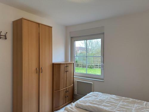 a bedroom with a bed and a window at Bungalow, Dornumersiel in Dornumersiel