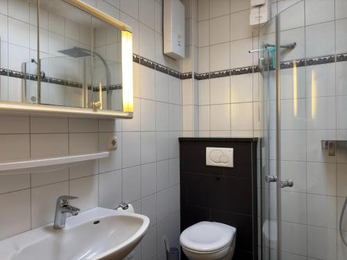 a bathroom with a toilet and a sink and a shower at Bungalow, Dornumersiel in Dornumersiel
