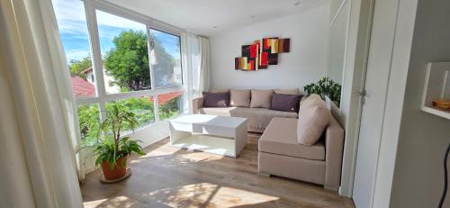 a living room with a couch and a large window at Departamento PH en Martinez in Martínez