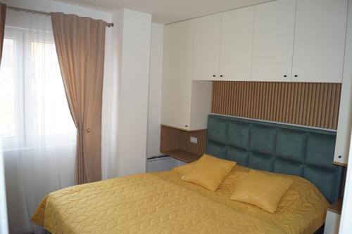 a bedroom with a bed with a blue headboard at Sekulic Apartman Tara in Konjska Reka