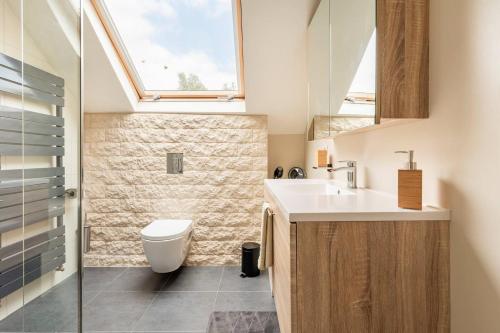 a bathroom with a sink and a toilet and a window at B&B De Schorre in Boom