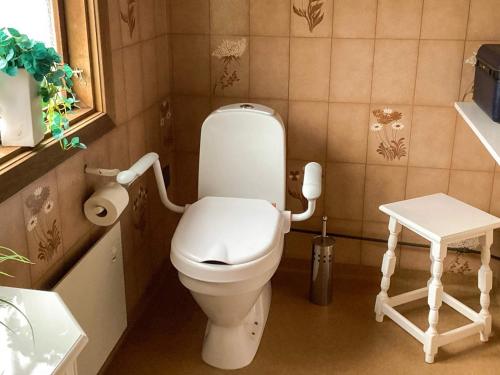 a bathroom with a white toilet and a stool at 4 star holiday home in ELDSBERGA in Eldsberga