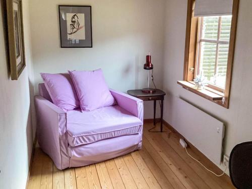 a purple chair in a living room with a table at 4 star holiday home in ELDSBERGA in Eldsberga