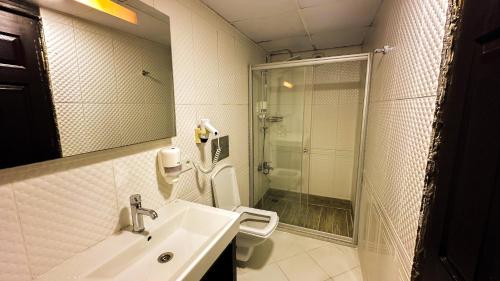 a bathroom with a sink and a toilet and a shower at Denizci Hotel in Sinop