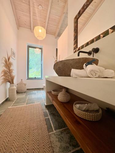a bathroom with a sink and a counter with towels at Villa Xalupi - Design-Villa mit Pool und Meerblick in Paleokastritsa