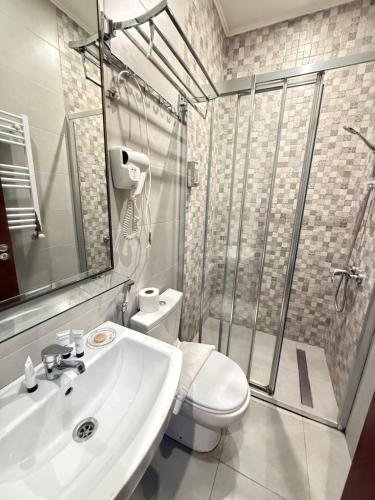 a bathroom with a toilet and a sink and a shower at Downtown Hotel in Tbilisi City