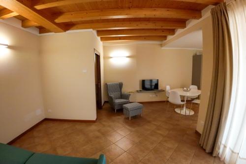 a living room with a table and chairs and a television at Casa Vacanze al Lago P1 in Monasterolo del Castello