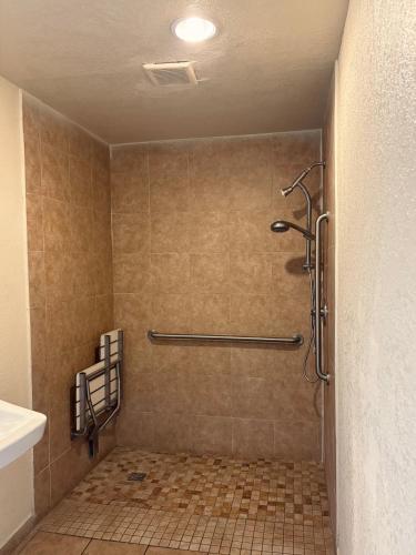 a bathroom with a shower with a tiled floor at Border Motel in Calexico