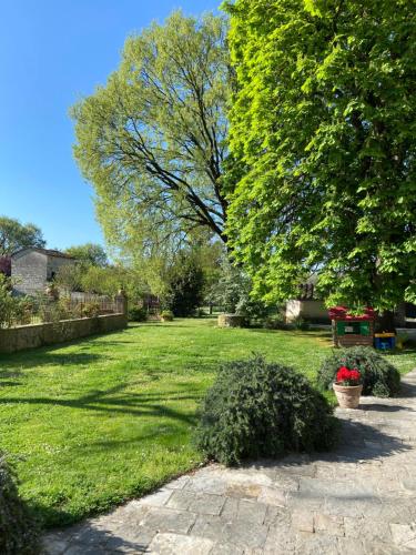 a garden with a lawn and trees on a sunny day at Agriturismo Del Casato in Sansepolcro