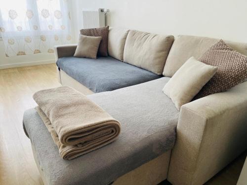 a living room with a couch with a blanket on it at Appartement cosy proche Paris CDG RER B Disneyland Paris Parc Astérix in Le Blanc-Mesnil