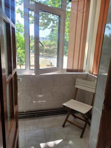 a bathroom with a bench and a window at La Mare Apartments - 25 in Constanţa
