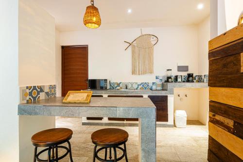 kuchnia z dwoma hokerami barowymi i blatem w obiekcie Kuun Taak Tulum w mieście Tulum
