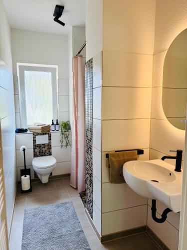 a bathroom with a sink and a toilet at Glacis Apartments I - Sonnenterasse & kostenlose Parkplätze in Minden