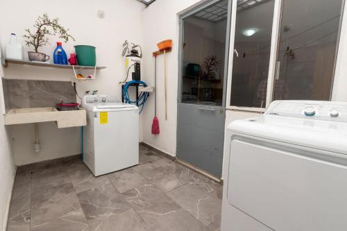 a laundry room with a sink and a washing machine at Habitación independencia in Morelia