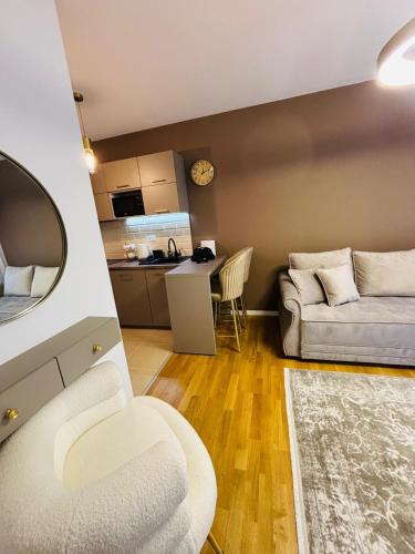 a living room with a couch and a kitchen at Apartman Merry Lux in Vrnjačka Banja