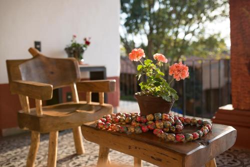 a wooden table with a potted plant and a chair at La Casita de la Basílica in Pátzcuaro