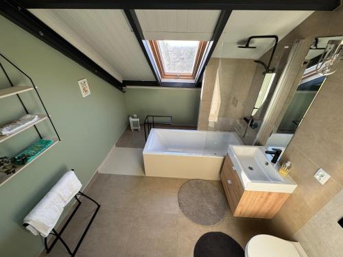 ein Badezimmer mit einer großen Badewanne und einem Waschbecken in der Unterkunft MECHELinn in Mechelinki