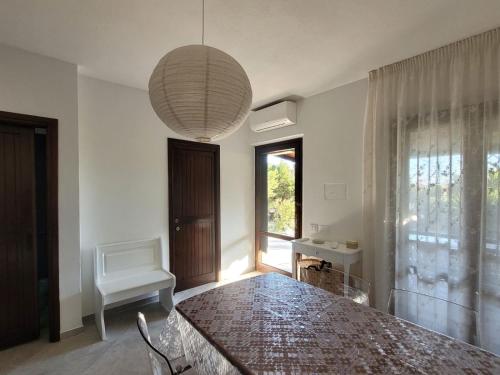 a dining room with a table and a chandelier at Villa il Gabbiano Stintino in Stintino