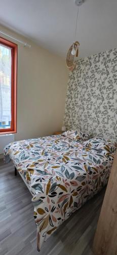 a bedroom with a bed with a colorful comforter at Appartement Pierre in Mers-les-Bains