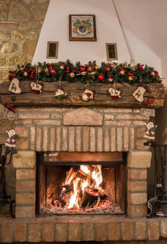 a fireplace with christmas decorations on top of it at Agriturismo Palazzo Bandino - Wine cellar, on reservation restaurant and spa in Chianciano Terme