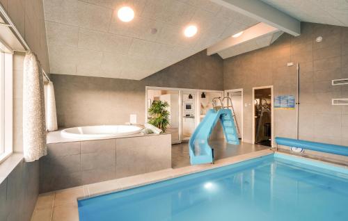 a large bathroom with a swimming pool and a tub at Nice Home In Ringkøbing With Sauna in Ringkøbing