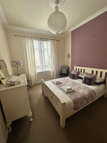 a bedroom with a large bed and a window at Castle Brae Apartment in Stirling